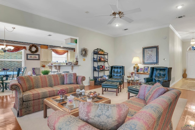 living room with light hardwood / wood-style floors, crown molding, and ceiling fan with notable chandelier