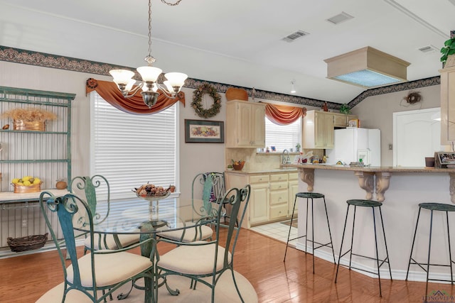 dining area featuring an inviting chandelier and light hardwood / wood-style flooring