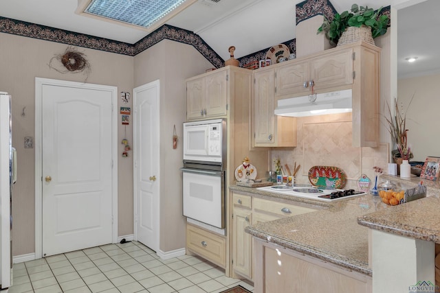 kitchen with light stone countertops, light tile patterned floors, and white appliances