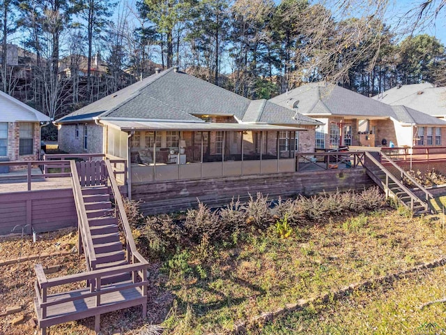 rear view of house with a wooden deck and a sunroom