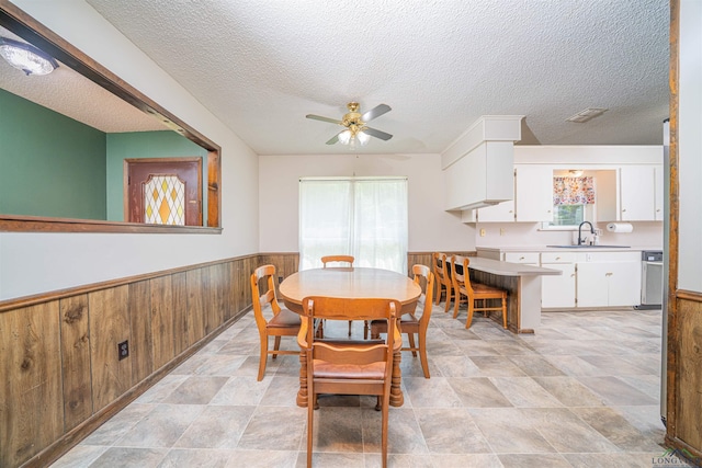4525 Surratt Rd, Longview, TX 75604 - dining area featuring a wainscoted wall, plenty of natural light, a textured ceiling, ceiling fan, and wood walls