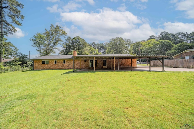 4525 Surratt Rd, Longview, TX 75604 - back of house with a chimney, brick siding, and a carport