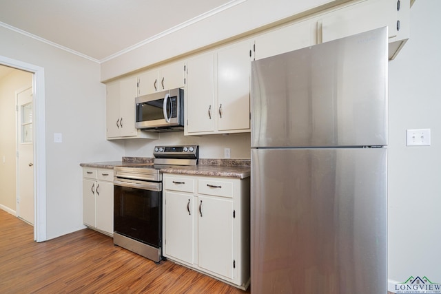 105 Sherwood Dr, Longview, TX 75605 - kitchen with white cabinets, stainless steel appliances, crown molding, and light wood-style floors