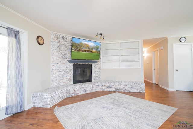 105 Sherwood Dr, Longview, TX 75605 - living area featuring a brick fireplace, ornamental molding, baseboards, and wood finished floors