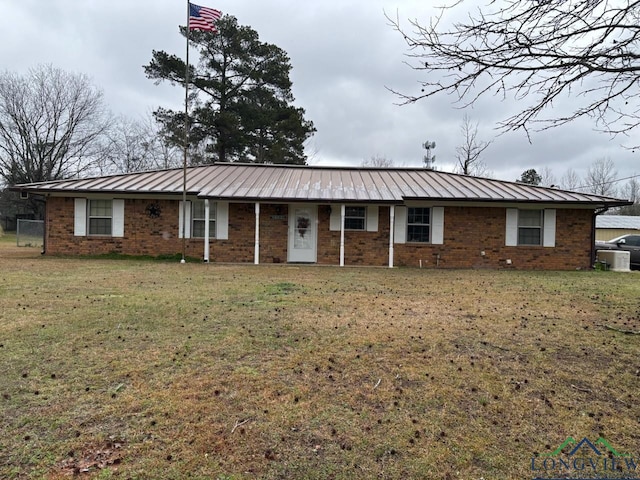 single story home featuring a front yard, a standing seam roof, brick siding, and metal roof