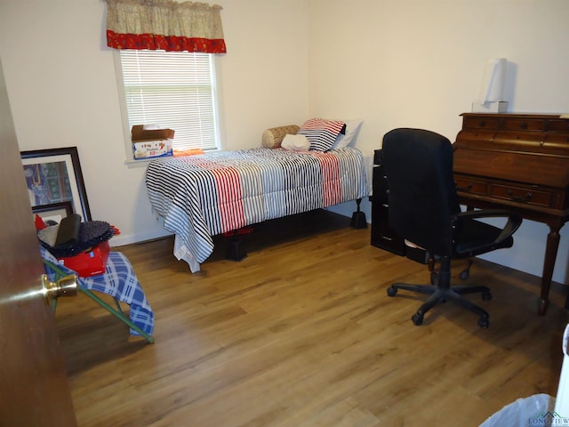 bedroom featuring wood finished floors and baseboards