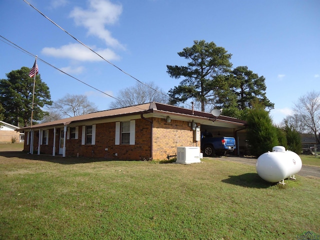 view of property exterior featuring driveway, an attached carport, a lawn, and brick siding