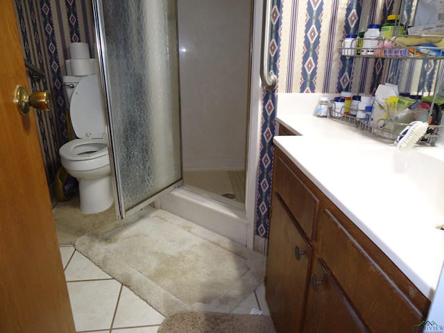 bathroom with toilet, a shower stall, vanity, and tile patterned floors