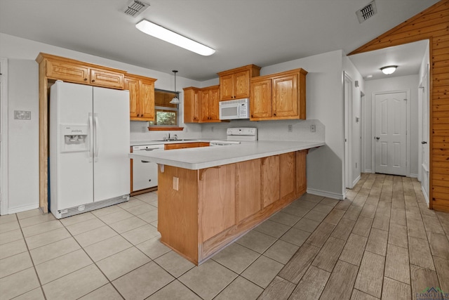 kitchen featuring sink, decorative light fixtures, wooden walls, white appliances, and kitchen peninsula