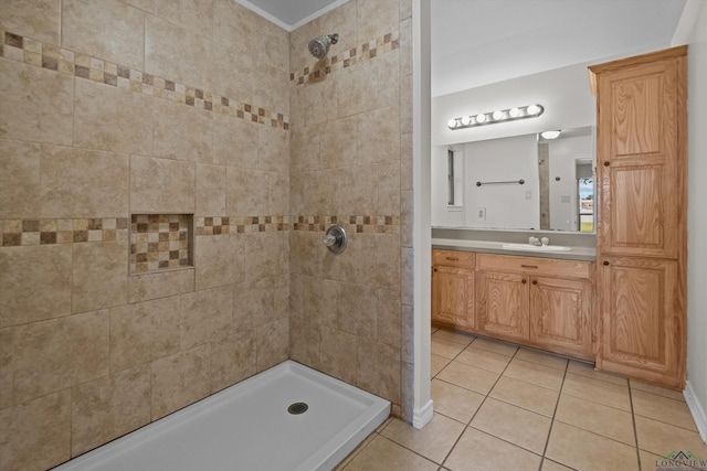 bathroom featuring tile patterned flooring, tiled shower, and vanity