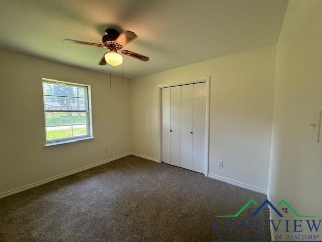 unfurnished bedroom featuring dark colored carpet, a closet, and ceiling fan