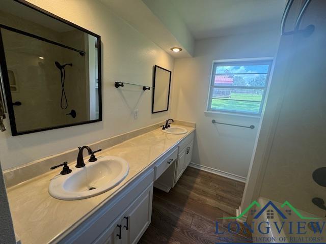 bathroom featuring vanity, wood-type flooring, and walk in shower