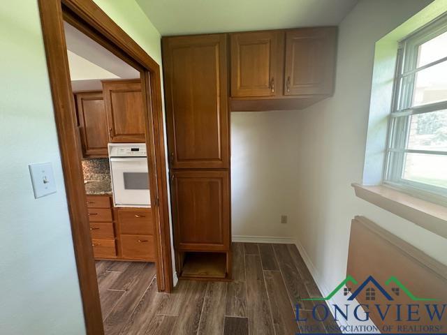 kitchen featuring tasteful backsplash, dark wood-type flooring, and white oven