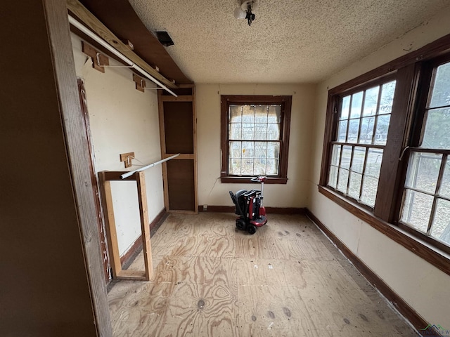 interior space with baseboards and a textured ceiling