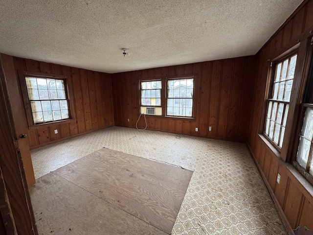 spare room featuring plenty of natural light, cooling unit, and a textured ceiling