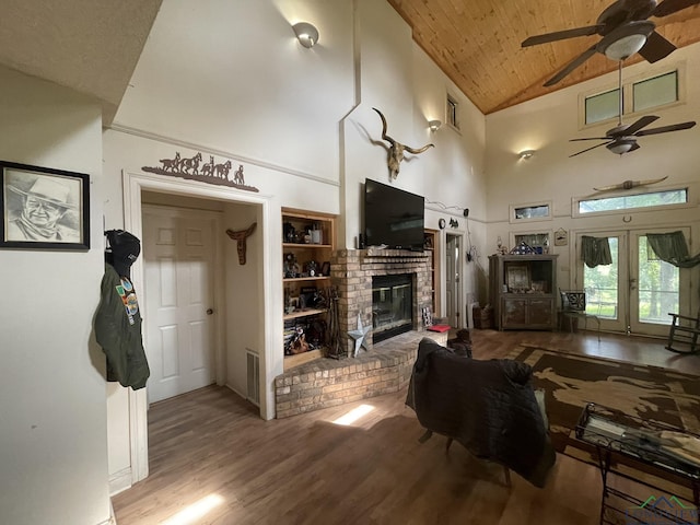 living room with french doors, a brick fireplace, high vaulted ceiling, wood-type flooring, and wood ceiling