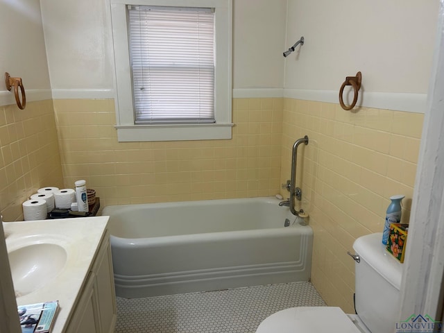 bathroom with vanity, toilet, tile walls, and a washtub