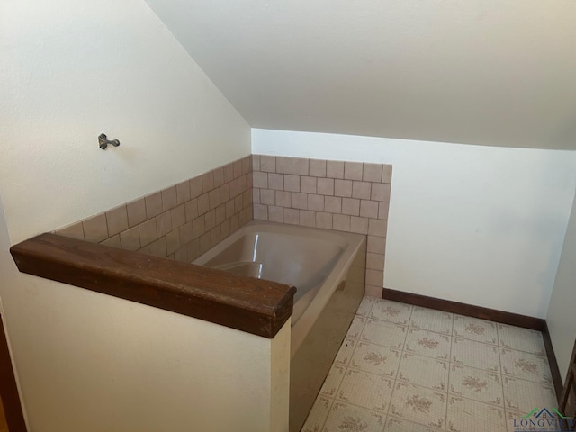 bathroom with a relaxing tiled tub and lofted ceiling