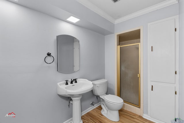 bathroom with hardwood / wood-style flooring, toilet, a shower with door, and ornamental molding