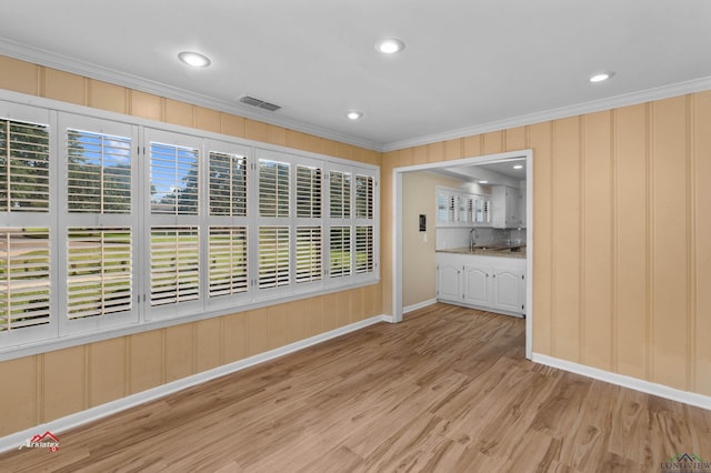 interior space with plenty of natural light, light wood-type flooring, and ornamental molding