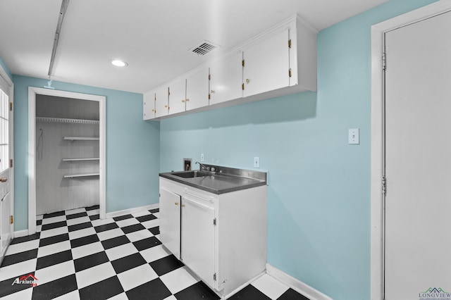 kitchen featuring white cabinets and sink