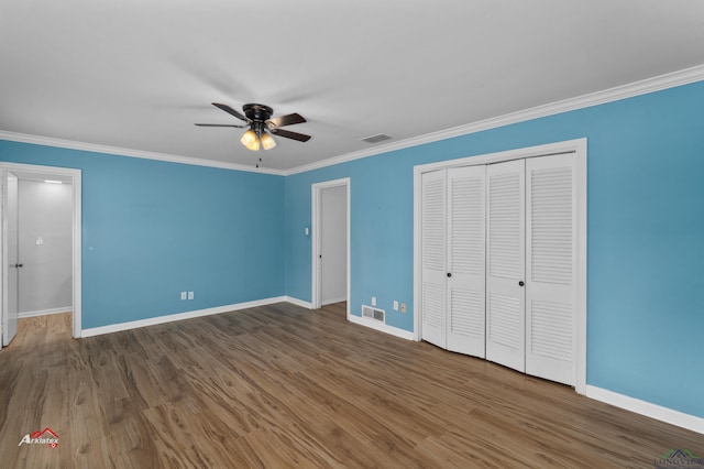 unfurnished bedroom with ceiling fan, crown molding, and dark wood-type flooring