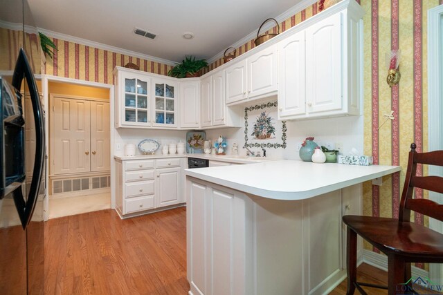 7 Casey Ct, Longview, TX 75604 - kitchen with freestanding refrigerator, a peninsula, a breakfast bar, white cabinets, and wallpapered walls