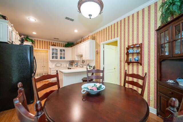 7 Casey Ct, Longview, TX 75604 - dining space featuring wallpapered walls, crown molding, and light wood-style floors