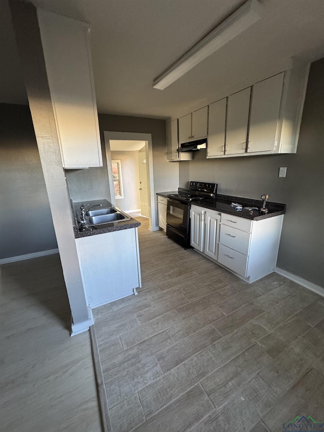 kitchen with black electric range oven, white cabinetry, and sink