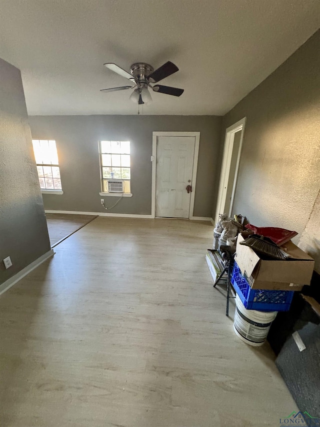 spare room with light hardwood / wood-style floors, ceiling fan, and cooling unit