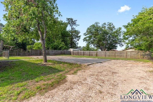 view of yard featuring driveway and a fenced backyard