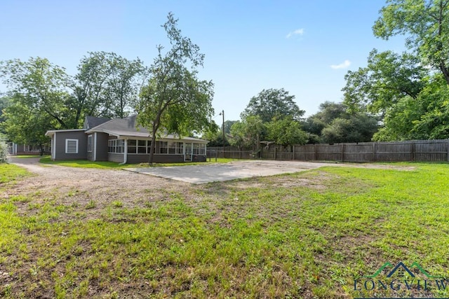 view of yard with a sunroom, fence, and a patio