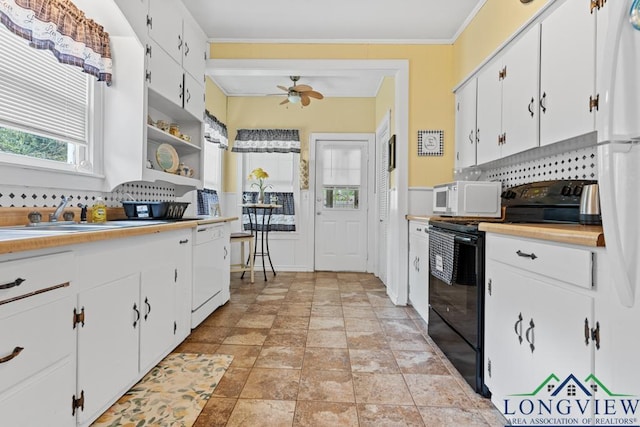 kitchen with white appliances, ceiling fan, crown molding, white cabinetry, and a sink