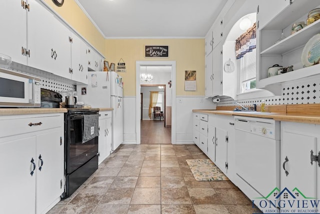 kitchen featuring white appliances, ornamental molding, light countertops, white cabinetry, and a sink
