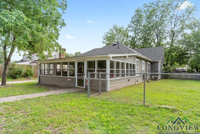 rear view of property with a sunroom, a chimney, fence, and a yard