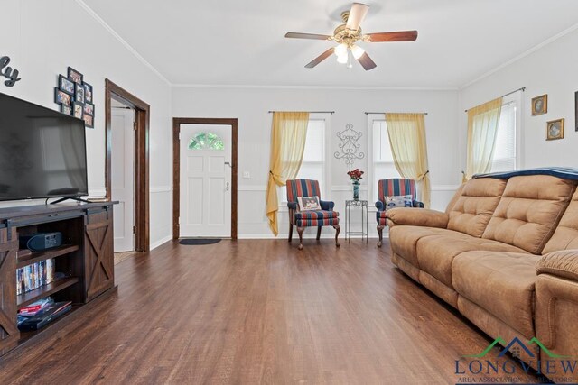 living room featuring dark wood-style floors, baseboards, a ceiling fan, and crown molding