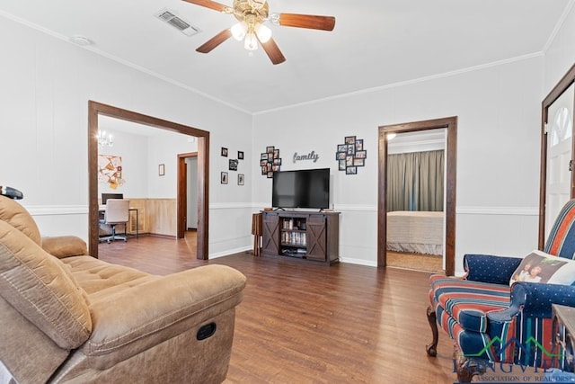 living area with ceiling fan, ornamental molding, wood finished floors, and visible vents
