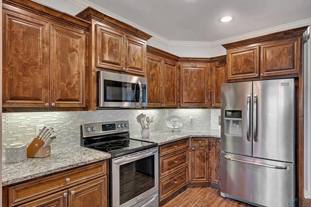 475 Highland Pl, Hallsville, TX 75650 - kitchen featuring tasteful backsplash, ornamental molding, light wood-type flooring, light stone counters, and appliances with stainless steel finishes