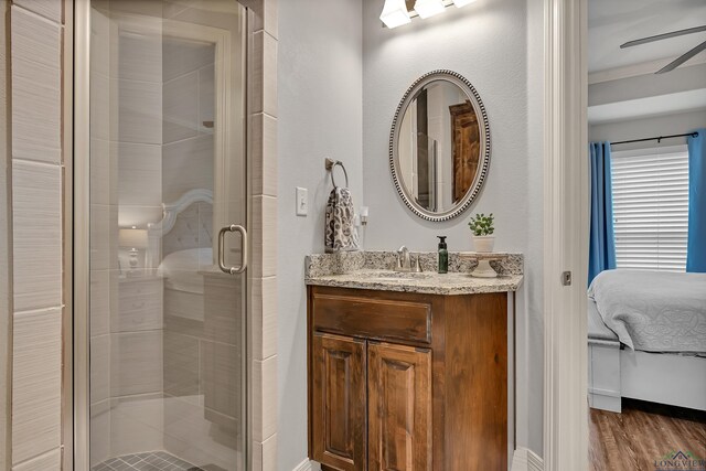 475 Highland Pl, Hallsville, TX 75650 - ensuite bathroom featuring connected bathroom, wood finished floors, a shower stall, ceiling fan, and vanity