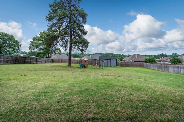 475 Highland Pl, Hallsville, TX 75650 - view of yard featuring a fenced backyard, a playground, a shed, and an outbuilding