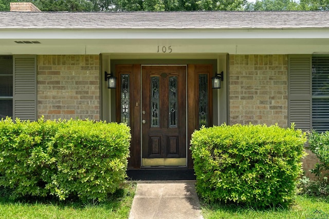105 Bison Trl, Longview, TX 75601 - entrance to property featuring brick siding, covered porch, and a shingled roof