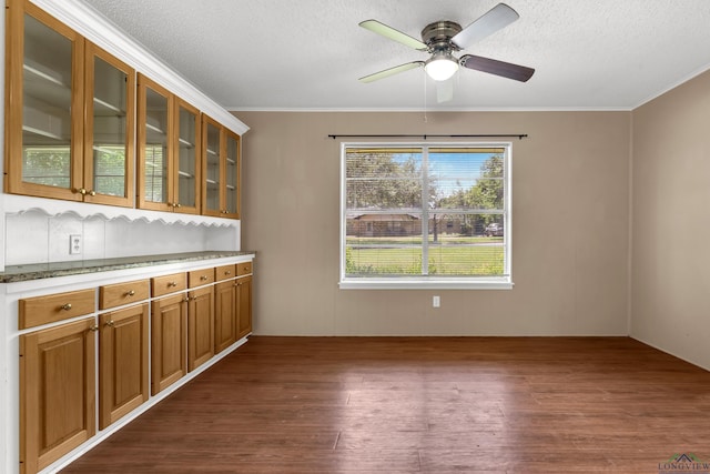 105 Bison Trl, Longview, TX 75601 - unfurnished dining area with dark wood-style flooring, a textured ceiling, ceiling fan, and ornamental molding