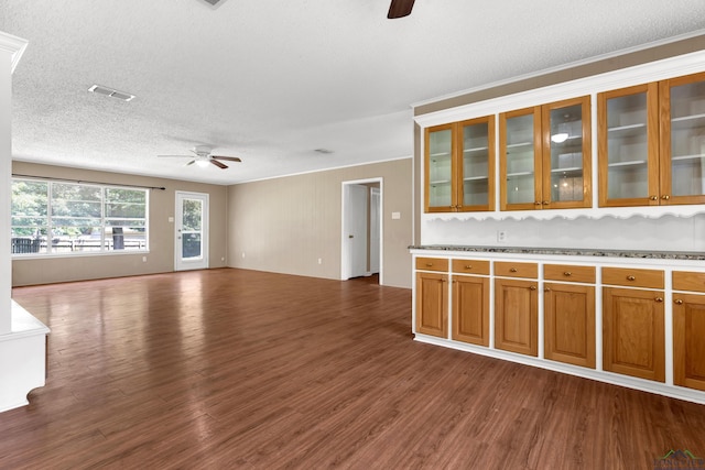 105 Bison Trl, Longview, TX 75601 - kitchen featuring a ceiling fan, dark wood-style flooring, a textured ceiling, open floor plan, and brown cabinets