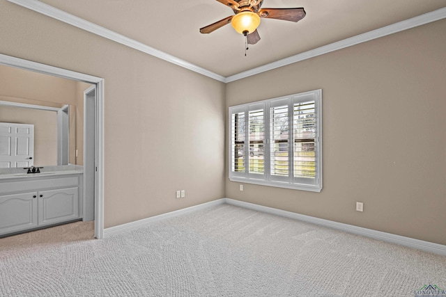 carpeted empty room with ceiling fan, ornamental molding, and sink