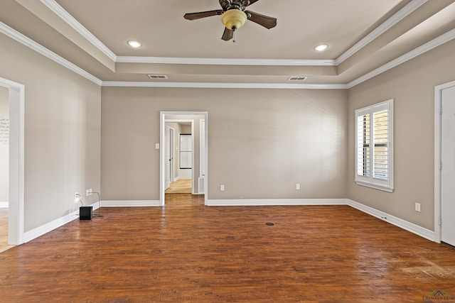 spare room with ceiling fan, dark hardwood / wood-style flooring, crown molding, and a tray ceiling