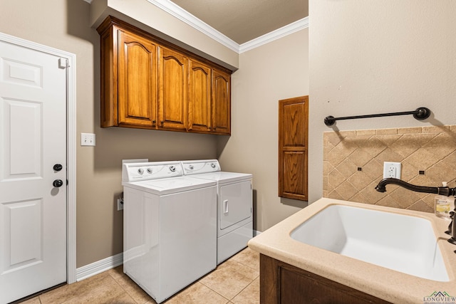 laundry room featuring washing machine and clothes dryer, sink, cabinets, crown molding, and light tile patterned floors