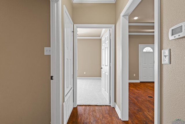 corridor with dark hardwood / wood-style flooring and crown molding