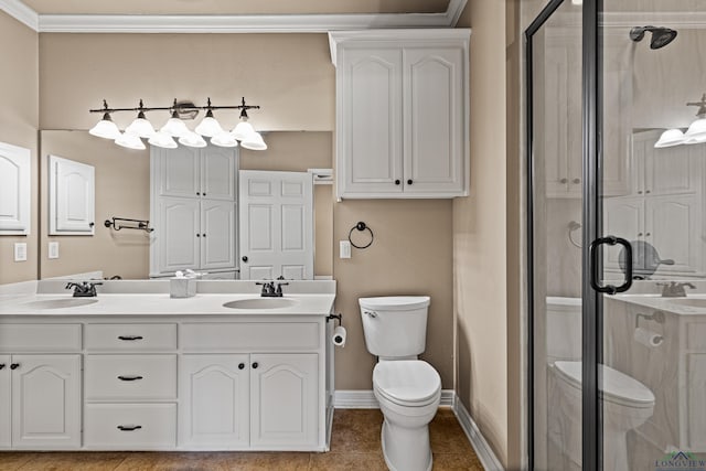 bathroom featuring vanity, a shower with door, tile patterned floors, crown molding, and toilet