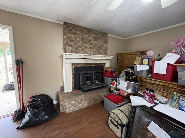 interior space featuring dark hardwood / wood-style flooring, a textured ceiling, a wood stove, and crown molding