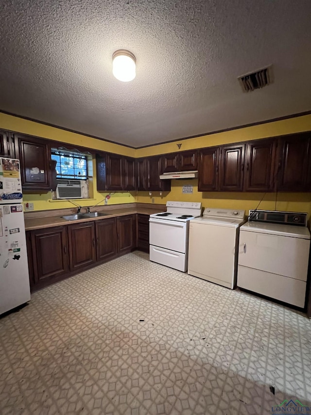 kitchen with washing machine and clothes dryer, sink, a textured ceiling, white appliances, and dark brown cabinets